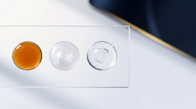 Trois textures d'actifs anti-âge — PDRN, exosomes et peptides — réunies sur surface de laboratoire