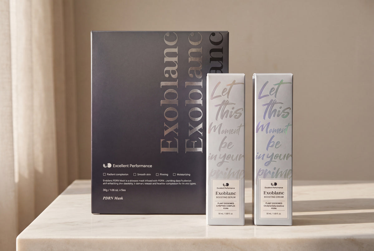 Sérum, crema y mascarilla ExoBlanc unidos sobre mármol: el ritual coreano antiedad completo